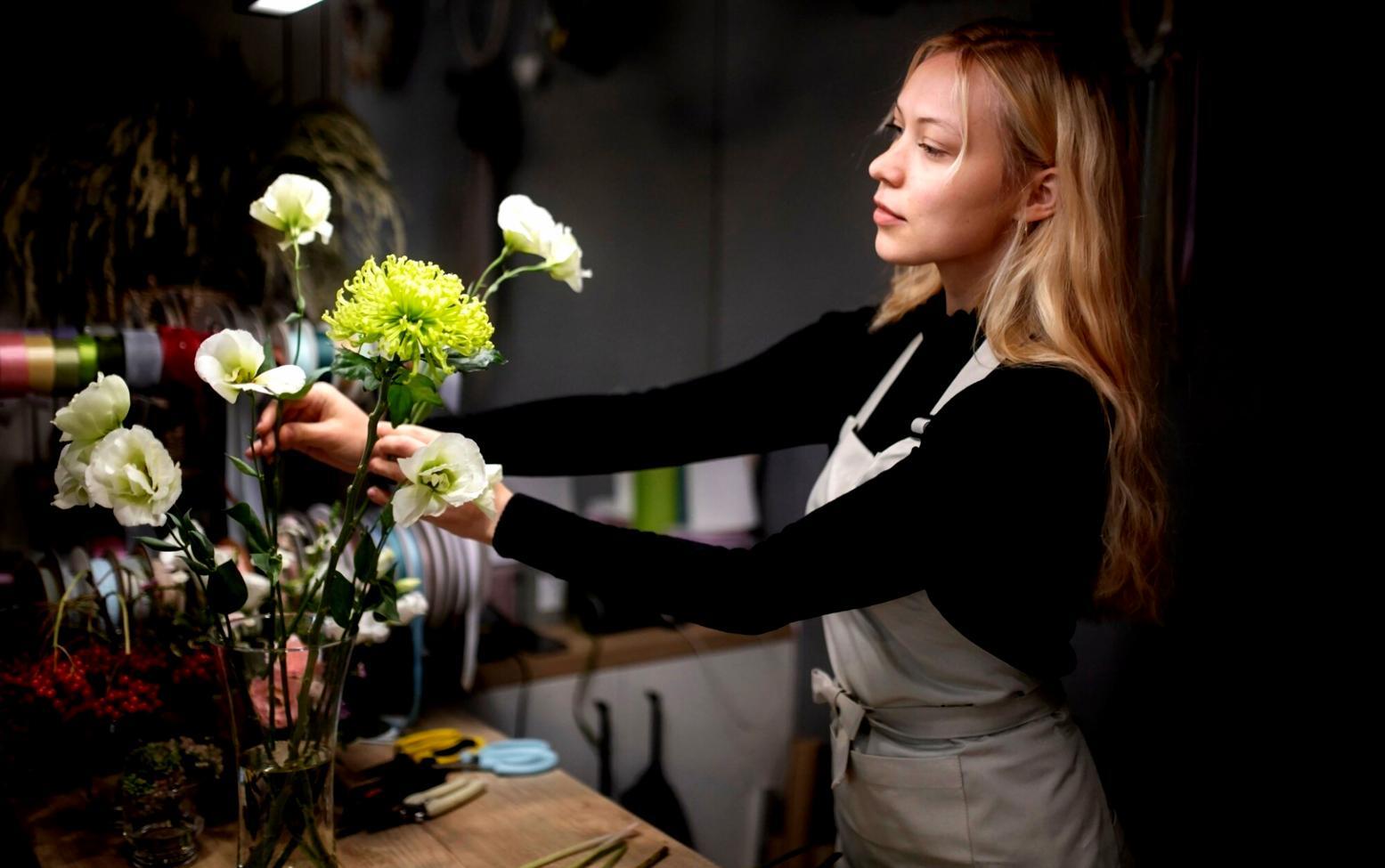 Detailed view of expert hands arranging flowers with precision and care